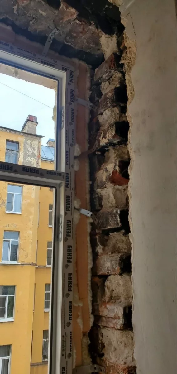 Кирпичная кладка у рамы и пена в шве
