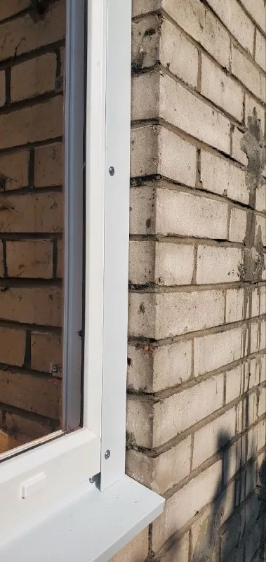 Рама у кирпичного фасада