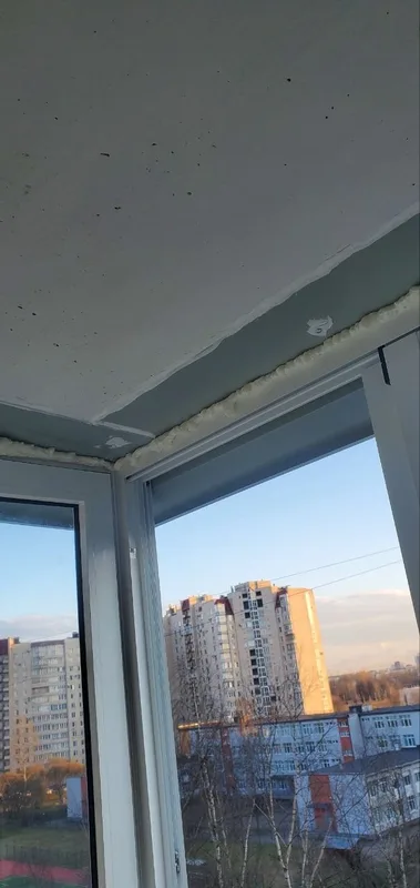 Пена по верху рамы под потолком балкона