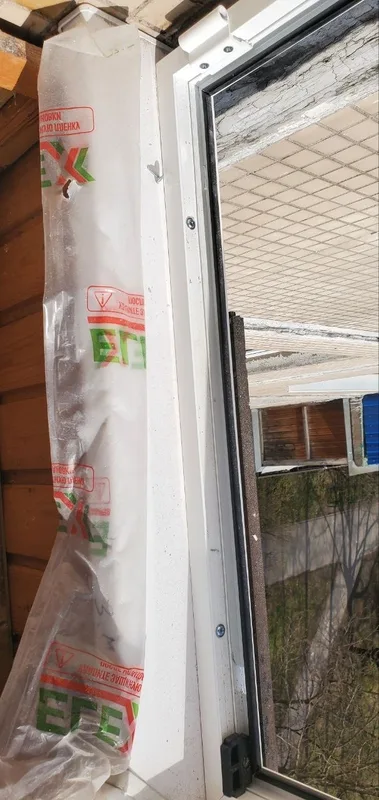 Створка и стойка рамы в защитной плёнке у деревянной обшивки