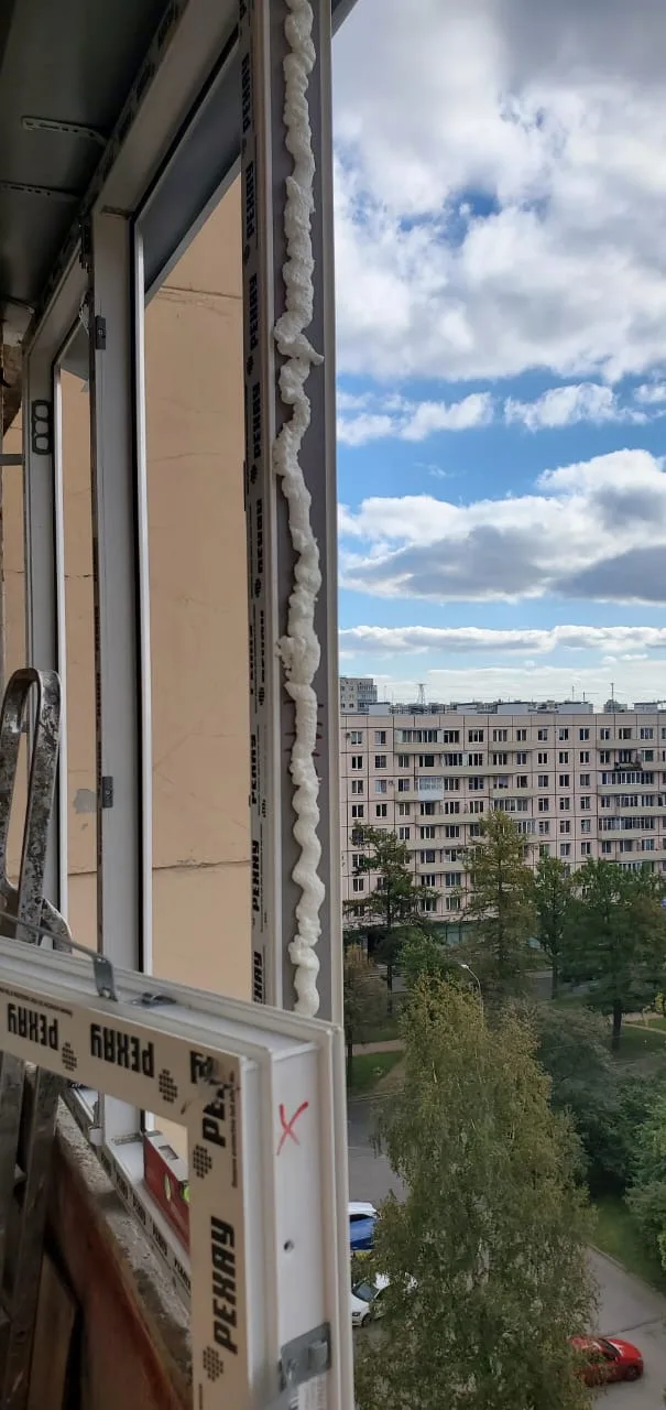 Рама в проёме с полосой пены по ребру, вид на двор и небо