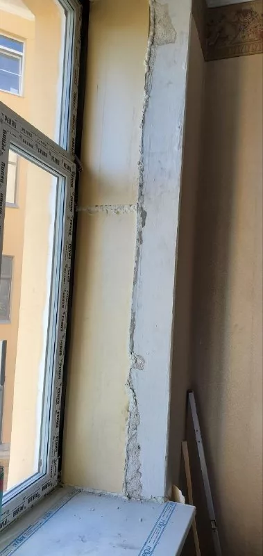 Окно у подоконника с оштукатуренными откосами